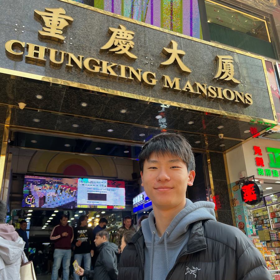 Ethan smiling in front of the entrance to Chungking Mansions in Hong Kong