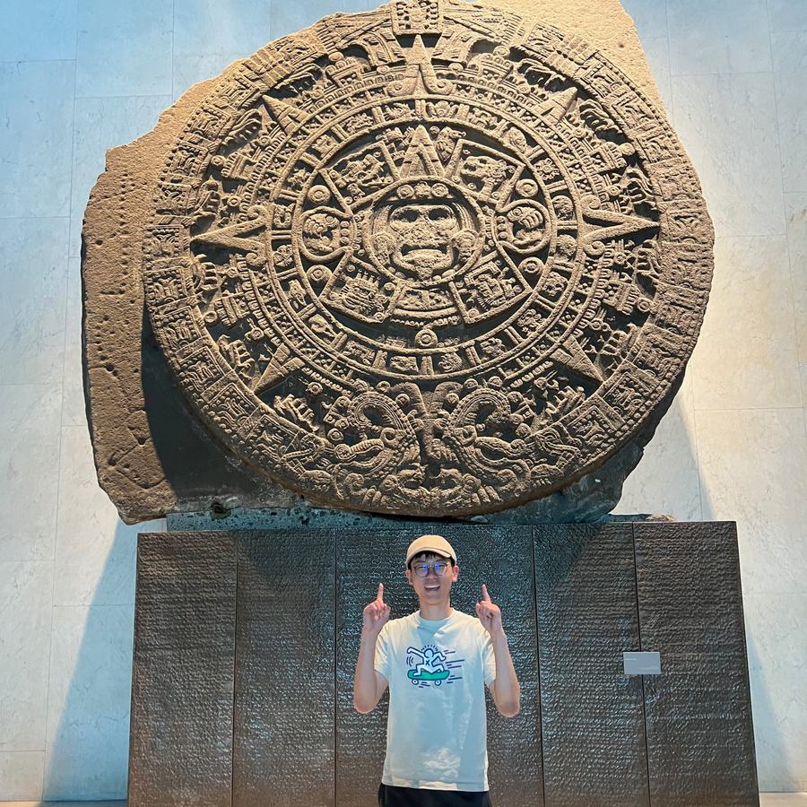 Ethan pointing up at the Aztec Sun Stone in the National Museum of Anthropology