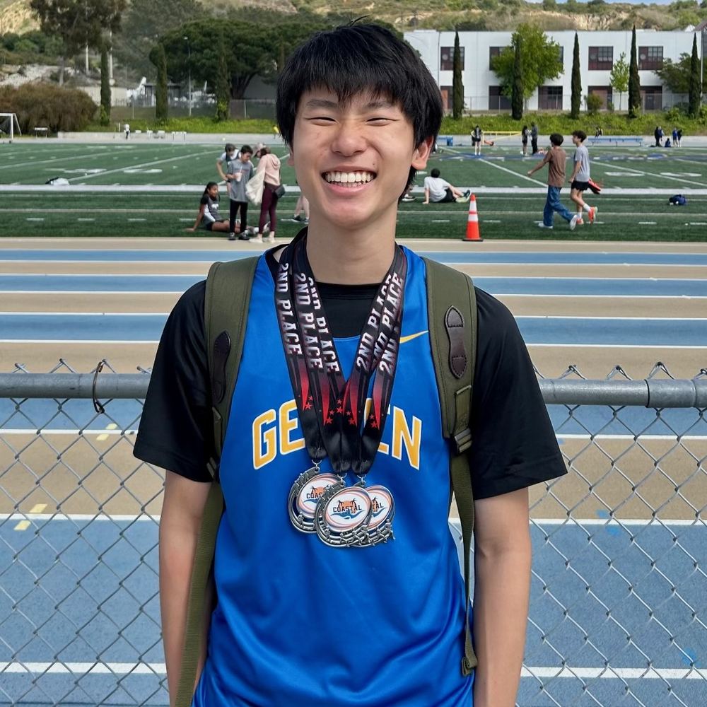 Ethan grinning with three second-place medals around his neck